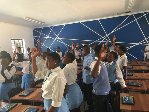Learners raising their hands during an interactive workshop