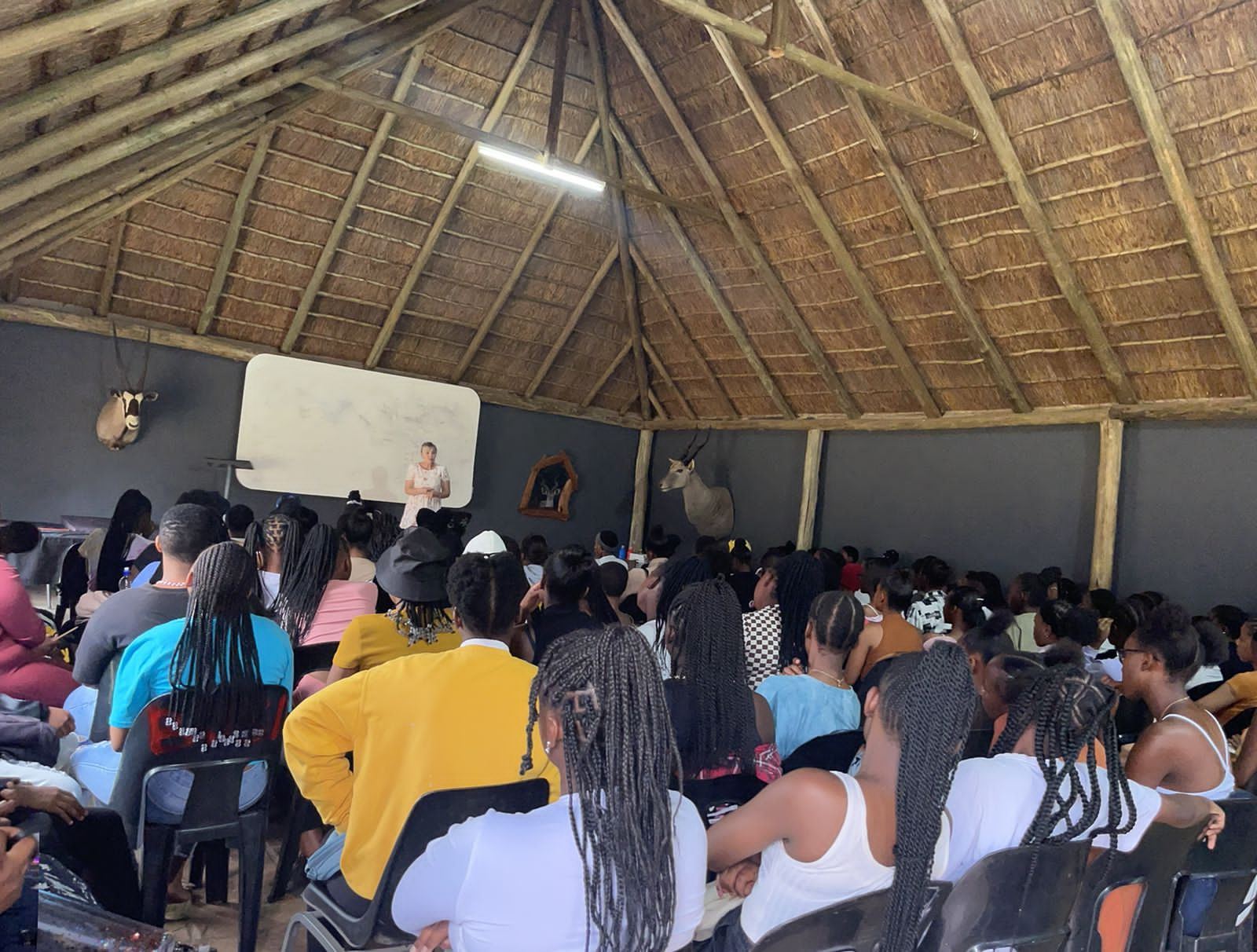 Learners listening to a facilitator in a hall